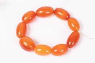An orange agate bead bracelet of nine oval beads, a gold opal and diamond stick pin,