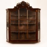 An 18th Century and later Dutch walnut glazed hanging cabinet with pierced and carved surmount,