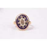 An oval gold coloured and enamel mount on a 22ct gold band,