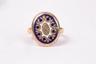 An oval gold coloured and enamel mount on a 22ct gold band,