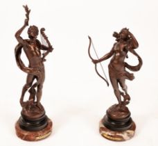 A pair of bronzed metal figures, Diana and Apollo on variegated marble bases,