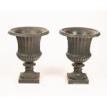 A pair of cast iron urns, green painted,