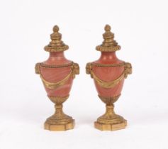 A pair of French ormolu mounted rouge marble cassoulet urns, with fruiting finial,
