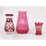 A cranberry glass vase etched scenes of pixies riding insects,