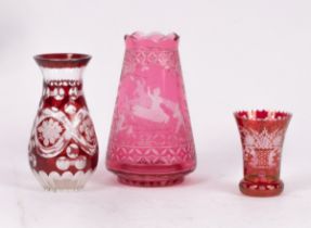 A cranberry glass vase etched scenes of pixies riding insects,