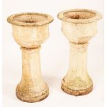 A pair of cast iron garden vases on tapered pedestal bases,