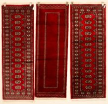 Three Bokhara runners, late 20th century, 179cm x 62cm, 182cm x 69cm,