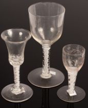 An English 18th Century wine glass with a bell bowl and solid base on a stem with two white spirals,