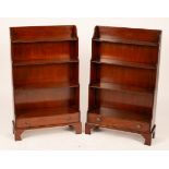 A pair of mahogany waterfall front open bookcases, each fitted a drawer and on bracket feet, 64.
