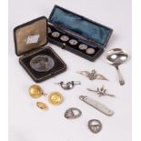 A set of four early 20th Century silver buttons, cased, a silver caddy spoon, a RAF badge,
