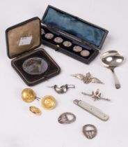 A set of four early 20th Century silver buttons, cased, a silver caddy spoon, a RAF badge,