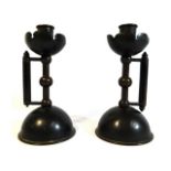 A pair of c.1886 bronze arts & crafts Christopher Dresser designed candle holders, loss to one lower
