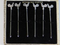 A boxed set of six sterling silver cocktail sticks