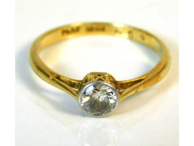 An 18ct gold ring with platinum collet set diamond