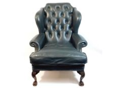 A green leather button back Chesterfield style armchair with ball & claw feet, 45in high to back