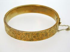 A 9ct gold bangle with chased decor, internal meas