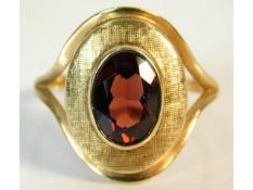 A yellow metal ring set with garnet, electronicall