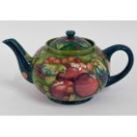 A Moorcroft pottery teapot with fruit decor, green