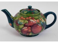 A Moorcroft pottery teapot with fruit decor, green