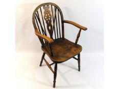 An antique elm wheel back armchair, 37in high to b