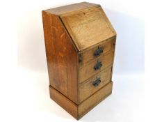 A small early 20thC. oak bureau set with three dra