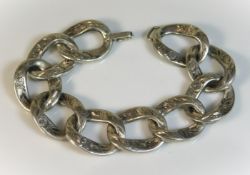 A silver large linked bracelet with chased decor,