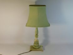 A 20thC. onyx lamp with brass footing, 25in tall