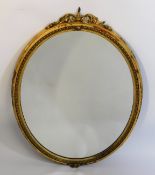 An antique gilt framed oval mirror, 35in high x 26