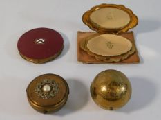 A brass globe compact & three other compacts inclu