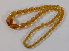 An amber faceted necklace, 24in long