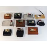 A selection of mounted vintage car ashtrays, boxes & pen holders, including Lesney