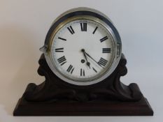 A steel clock mounted on carved wooden plinth, 13.