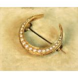 An antique yellow metal crescent shaped brooch set