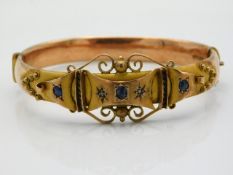 An antique 9ct rose & yellow gold bangle set with sapphire & diamond, internal measurement 59mm diam