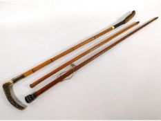 A 32.75in long cane riding crop with horn handle with inscribed collar, twinned with a swagger stick