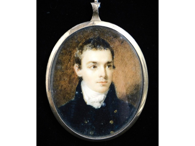 A miniature portrait of a young gentleman in dark blue coat with brass buttons & white cravat, set i