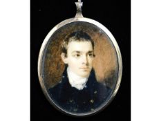 A miniature portrait of a young gentleman in dark blue coat with brass buttons & white cravat, set i