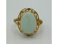 A 9ct gold jade ring with Oriental styled mount, stone 11mm high, 3.4g, size M/N