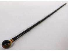 A walking cane with spherical tiger eye handle & gilt mounting engraved "Beatrice", 33in long