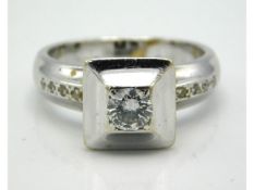 A white metal ring set with central diamond of 0.33ct & eight small diamonds to the shoulders, some