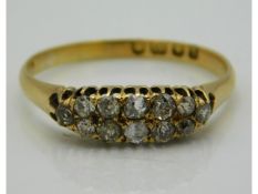 An antique 18ct gold ring set with twelve small diamonds, evidence of glue on end diamond, approx. 0