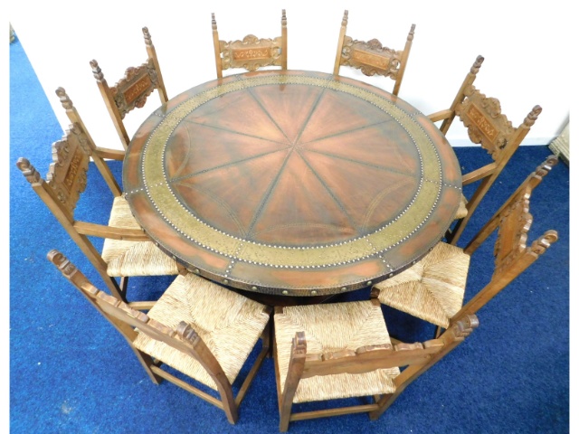 An unusual copper encased circular dining table with six chairs & two carvers, diameter 59.25in x 30