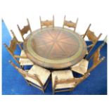 An unusual copper encased circular dining table with six chairs & two carvers, diameter 59.25in x 30