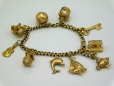 A 9ct gold & yellow metal charm bracelet, 26.1g