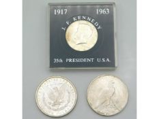 An 1888 silver US dollar with lustre twinned with a 1924 silver dollar & a J. F. Kennedy 35th Presid