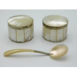 A pair of white metal mounted mother of pearl lidded boxes twinned with mother of pearl caviar spoon