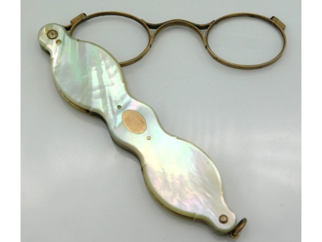 A pair of gold framed mother of pearl lorgnettes, 4.25in wide folded, electronically test as 14ct, 3