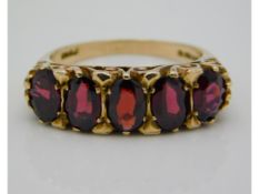 A 9ct gold five stone garnet ring with carved bridge, 5.1g, size M