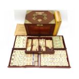 An early/mid 20thC. cased Chinese five drawer bone Mahjong set twinned with various instruction manu