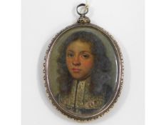 A 17thC. oil miniature of young gentleman wearing lace collar set within a chased silver frame. Imag